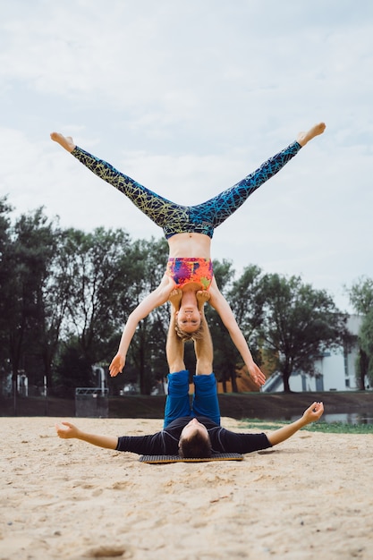 pareja joven practicando yoga en el fondo de la ciudad