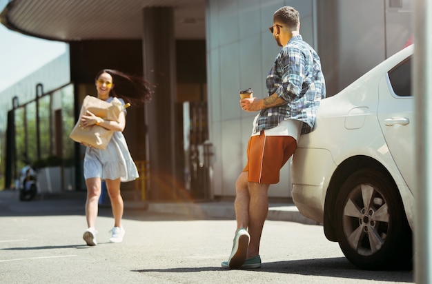 Pareja joven preparándose para un viaje de vacaciones en el coche en un día soleado