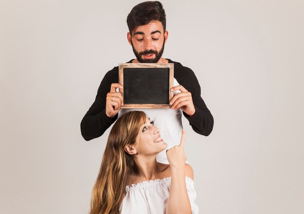 Pareja joven presentando pizarra