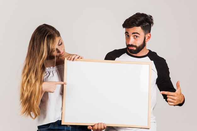 Foto gratuita pareja joven presentando tabla