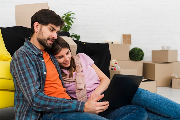 Foto gratuita pareja joven relajada romántica en casa moderna usando laptop