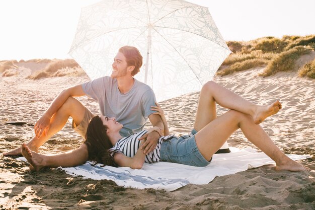 Pareja joven relajando por la playa