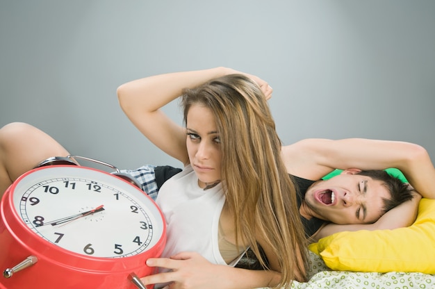 Pareja joven con reloj despertador