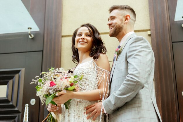 Pareja joven romántica caucásica celebrando su matrimonio en la ciudad.