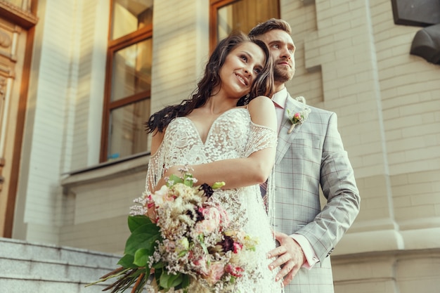 Pareja joven romántica caucásica celebrando su matrimonio en la ciudad.