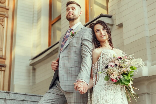 Pareja joven romántica caucásica celebrando su matrimonio en la ciudad.