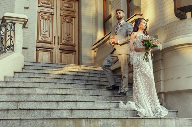 Pareja joven romántica caucásica celebrando su matrimonio en la ciudad.