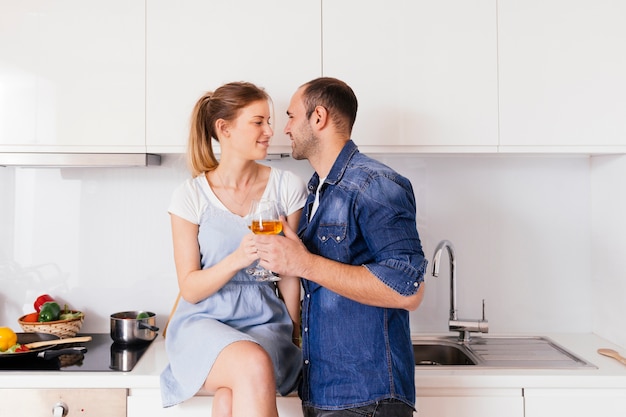 Pareja joven romántica sosteniendo copas en la mano mirando el uno al otro