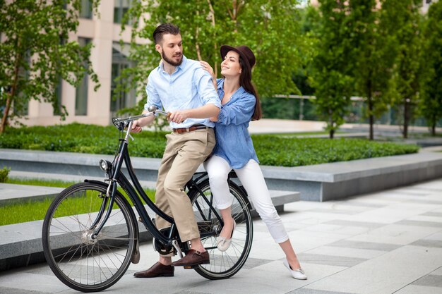 Pareja joven sentada en una bicicleta