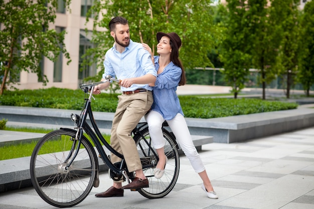 Pareja joven sentada en una bicicleta