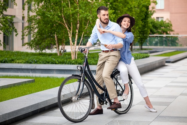 Pareja joven sentada en una bicicleta