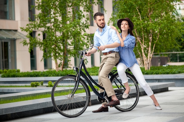 Pareja joven sentada en una bicicleta