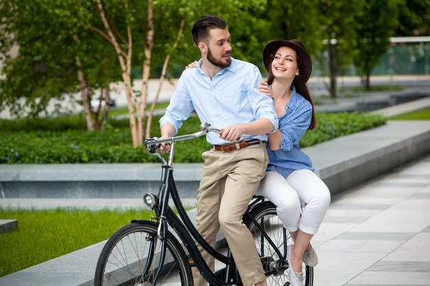 Pareja joven sentada en una bicicleta