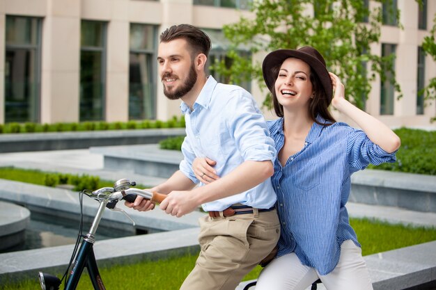 Pareja joven sentada en una bicicleta