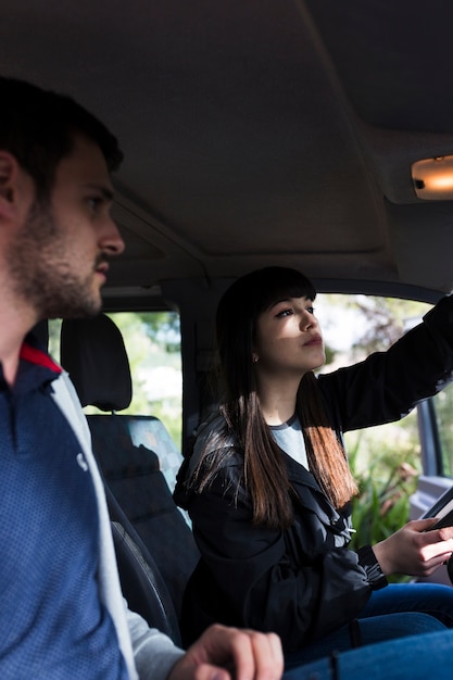 Pareja joven sentada en el coche