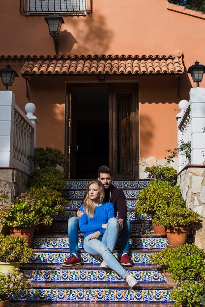 Pareja joven sentada en el porche