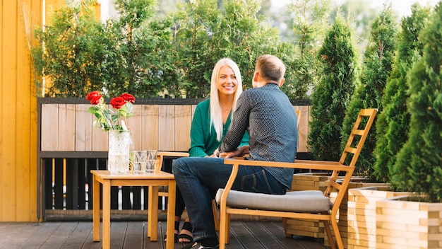 Pareja joven sentado en la terraza del patio