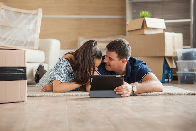 Foto gratuita pareja joven sintiéndose feliz en su nueva casa. pareja hablando sobre el futuro.