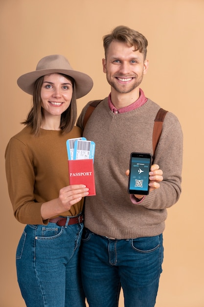 Pareja joven con smartphone y billetes de avión para viajar