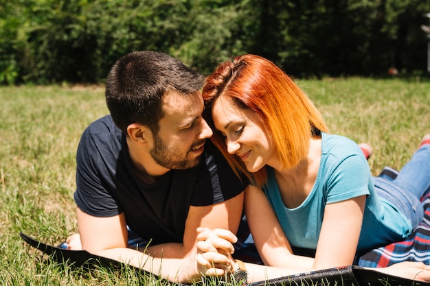 Pareja joven sonriente disfrutando en el parque