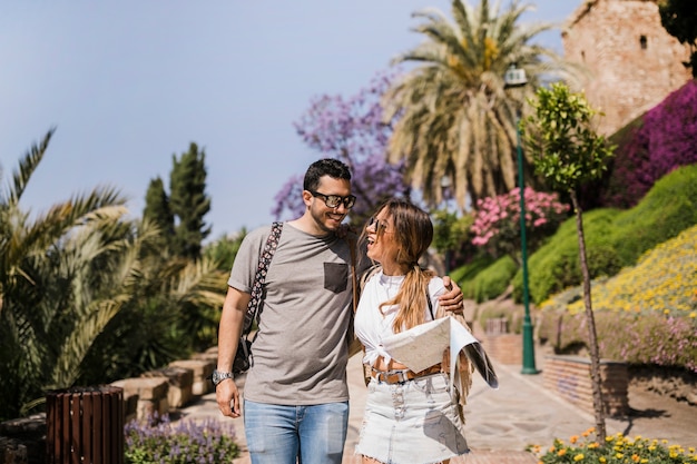 Foto gratuita pareja joven sonriente de pie en el parque