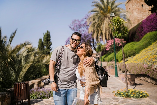 Pareja joven sonriente de pie en el parque