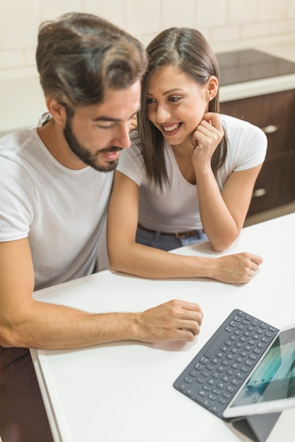 Foto gratuita pareja joven con tableta en cocina