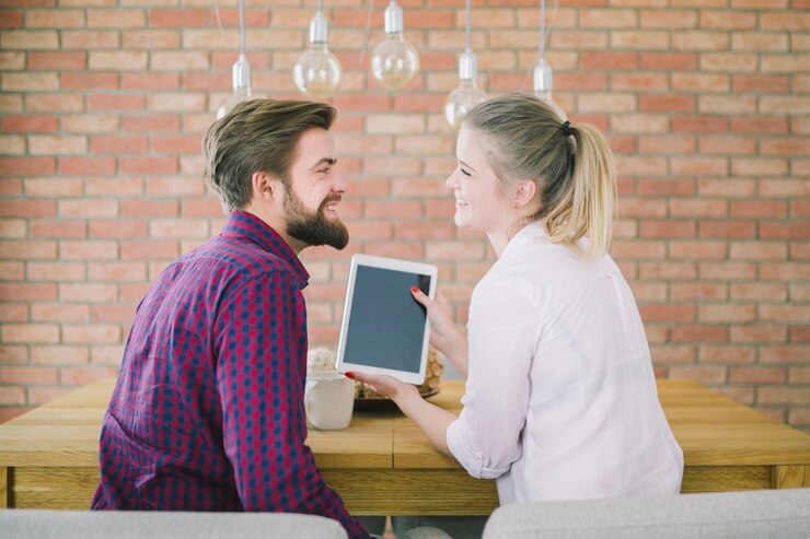 Foto gratuito pareja joven con tableta en la mesa
