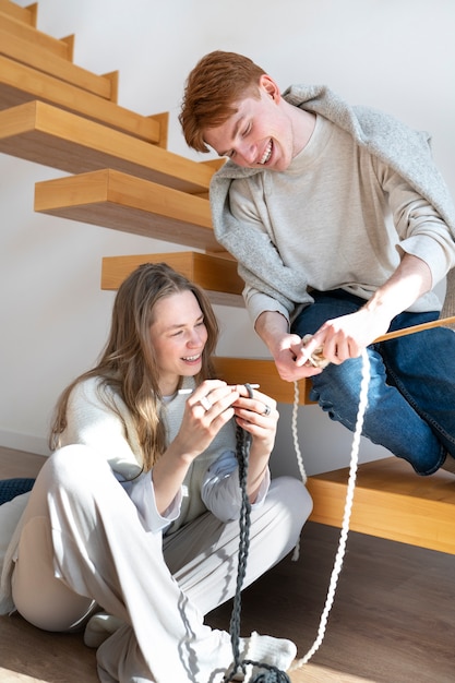 Foto gratuita pareja joven tejiendo juntos