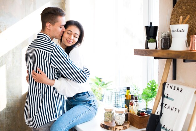 Pareja joven teniendo momento romántico en la cocina