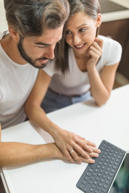 Foto gratuita pareja joven tocando el teclado de la tableta