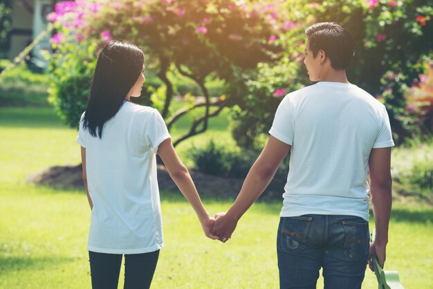 Pareja joven tomados de la mano caminando juntos