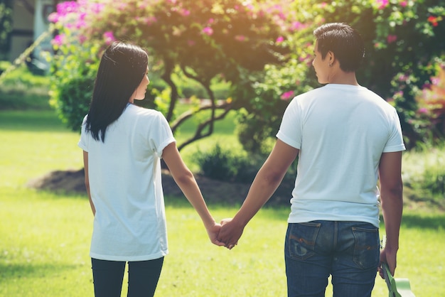 Pareja joven tomados de la mano caminando juntos