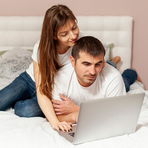 Pareja joven trabajando en la computadora portátil desde casa