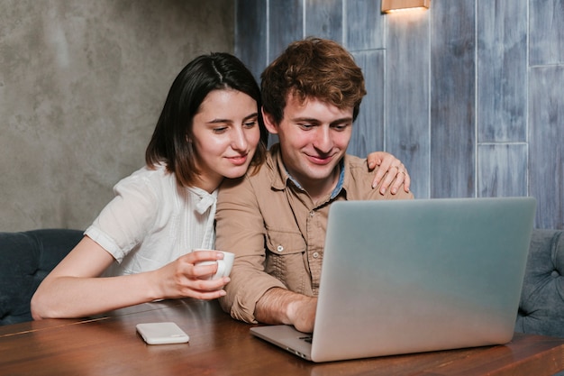 Foto gratuita pareja joven trabajando en la computadora portátil