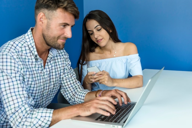 Foto gratuita pareja joven trabajando con portátil