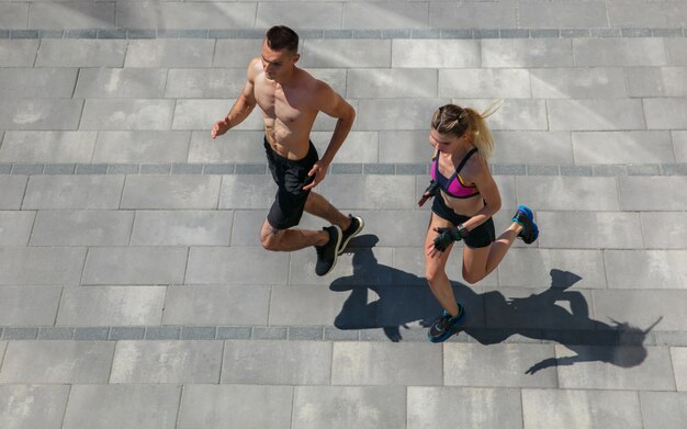 Pareja joven en traje deportivo haciendo ejercicio matutino al aire libre.