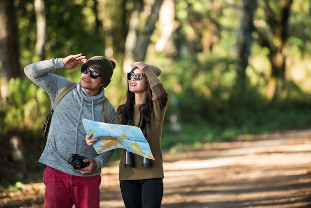 Pareja joven turista viaja en bosque de montaña