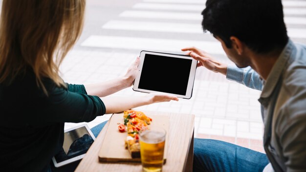 Pareja joven usando tableta en café