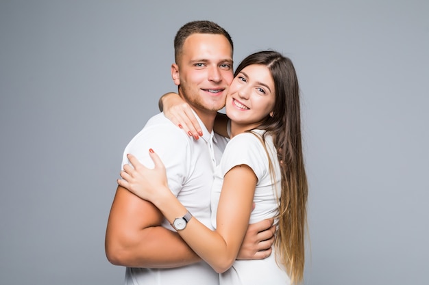 Pareja joven vestida con camisetas blancas con románticos abrazos amistosos aislados