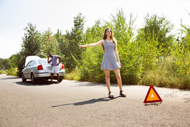 Pareja joven viajando en coche en día soleado