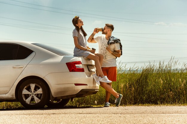 Pareja joven viajando en el coche en un día soleado