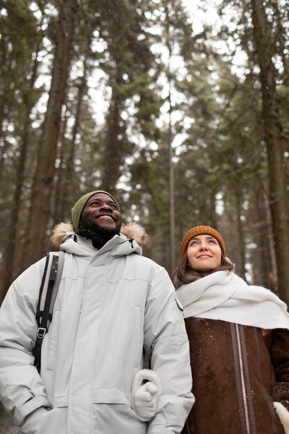 Pareja joven en un viaje por carretera de invierno juntos caminando por el bosque