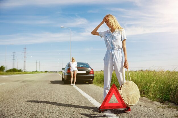 Pareja joven va de viaje de vacaciones en el coche en un día soleado