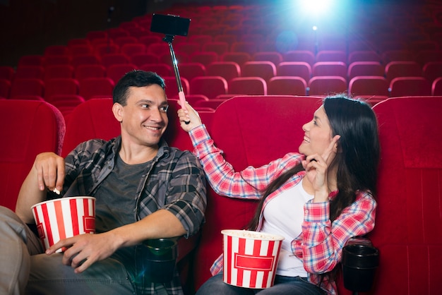 Foto gratuita pareja joven viendo película en cine