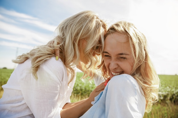 La pareja de jóvenes lesbianas averió el coche mientras viajaba camino de descansar. Besos y abrazos en el maletero del coche. Relación, problemas en la carretera, vacaciones, vacaciones, concepto de luna de miel.