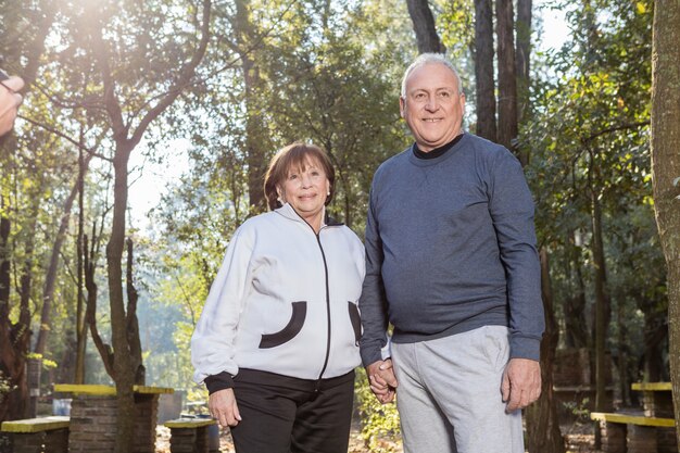 Pareja de jubilados sonriendo al aire libre