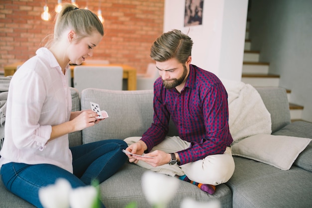 Foto gratuita pareja jugando a las cartas en el sofá