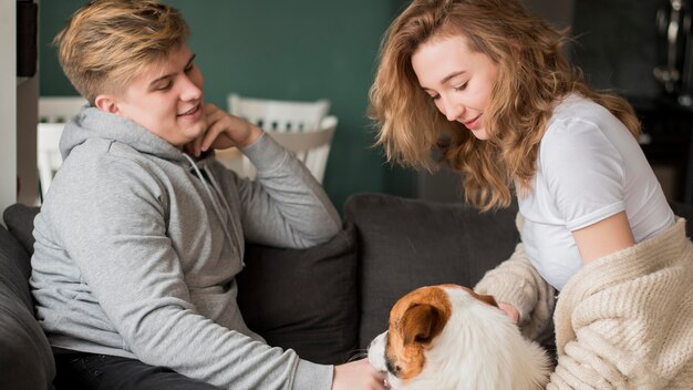 Pareja jugando con perro en casa