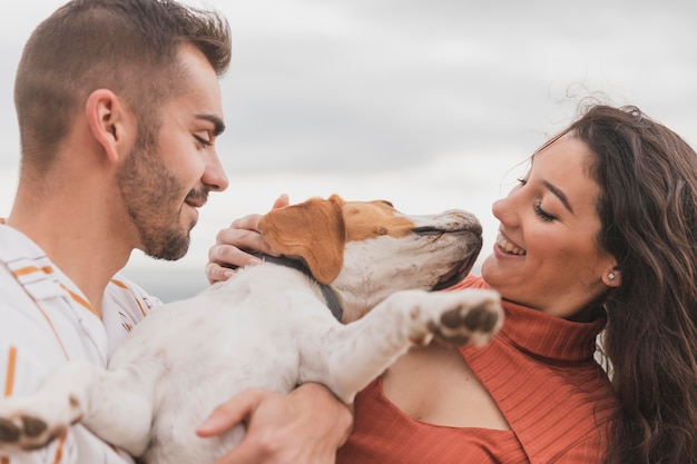 Foto gratuita pareja jugando con perro